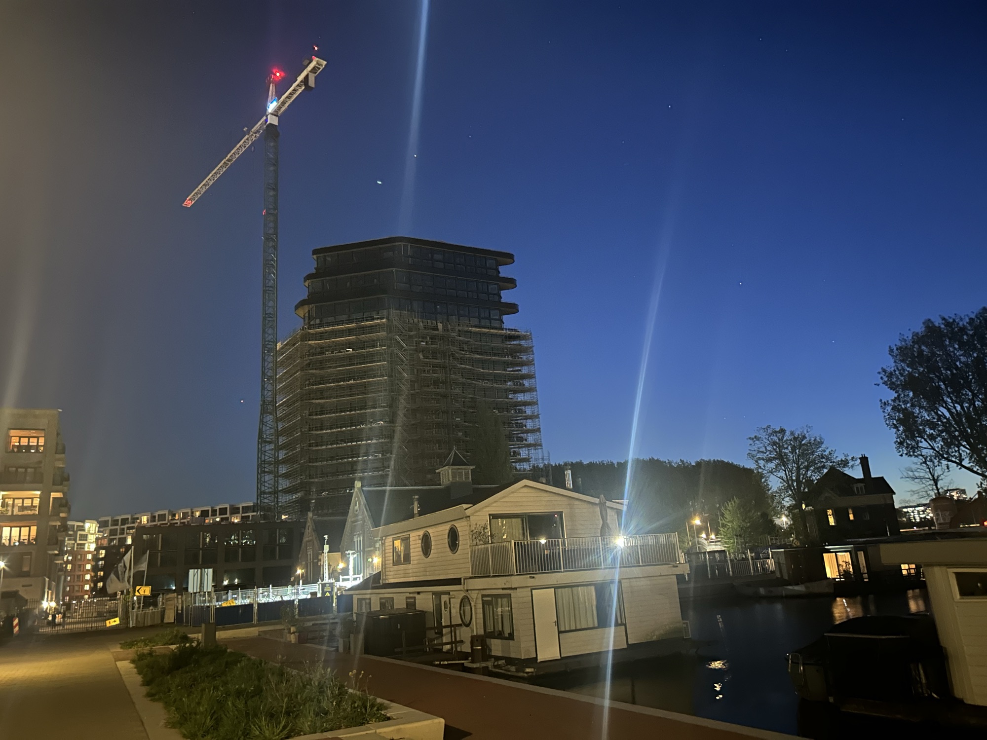 O Elements visto à noite, com guindaste e luzes refletindo na água